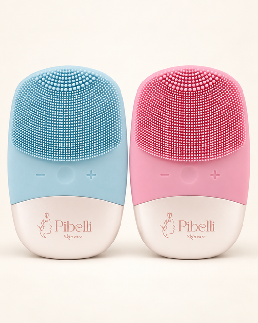 Two Pibelli skin care cleansing brushes in pastel blue and pastel pink, side-by-side on a warm off-white background.